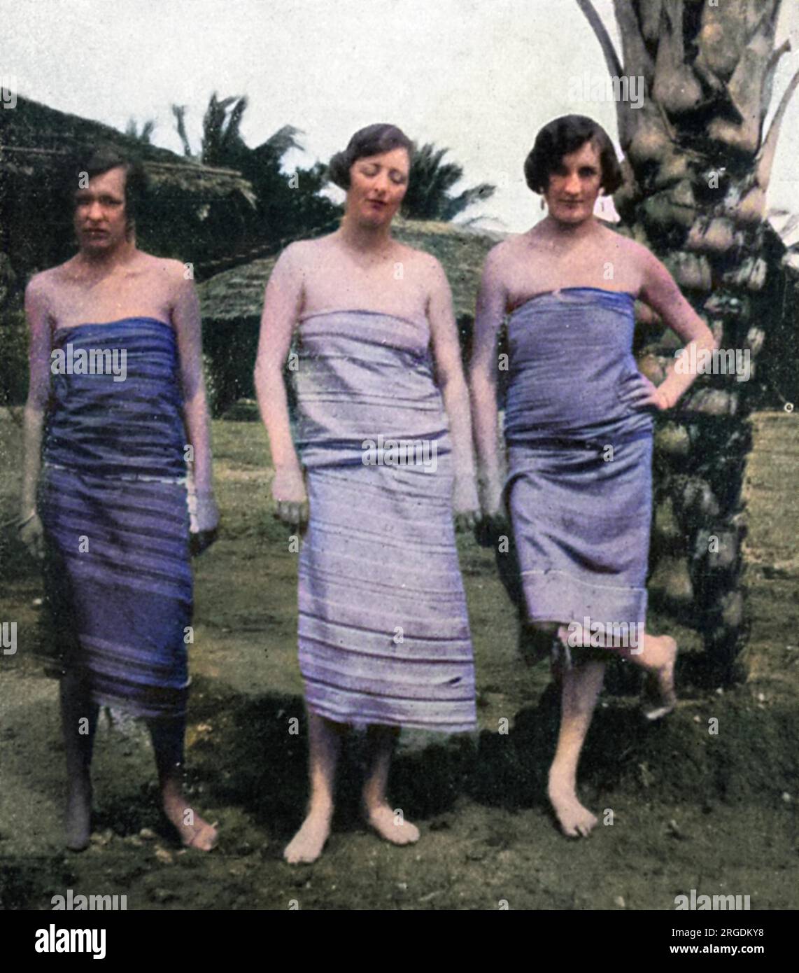 Lady Idina Hay (nee Sackville), pictured in a sarong or kanga with two friends in Kenya during the 1920s, while she was married to Josslyn Hay, Earl of Erroll.  On the left is the Countess N. de Graevenitz and on the right, Mrs. M. Roberts, both similarly attired.  Five-times married Idina would gain notoriety as part of the Happy Valley Set when she moved to Kenya in 1924 with her third husband, Josslyn Hay, Earl of Errol. With her serial marriages and reputation for debauched decadence, she inspired the character of 'The Bolter' in Nancy Mitford's novels, The Pursuit of Love and Love in a Co Stock Photo