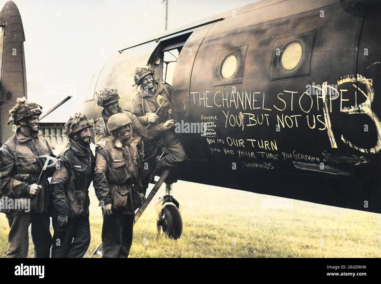 A team of paratroopers on 7 June 1944 amuse themselves whilst awaiting the call to take flight in their glider (an Airspeed Horsa) to back up the initial assault phase on the Normandy coast. The chalk slogan reads: 'The Channel stopped you, but not us - now it's our turn. You've had your time you German Schweinhunds'!  D-Day began on 6 June 1944 at 6:30am and was conducted in two assault phases û the air assault landing of allied troops followed by an amphibious assault by infantry. The Normandy landings were the largest single-day amphibious actions ever undertaken, involving close to 400,000 Stock Photo