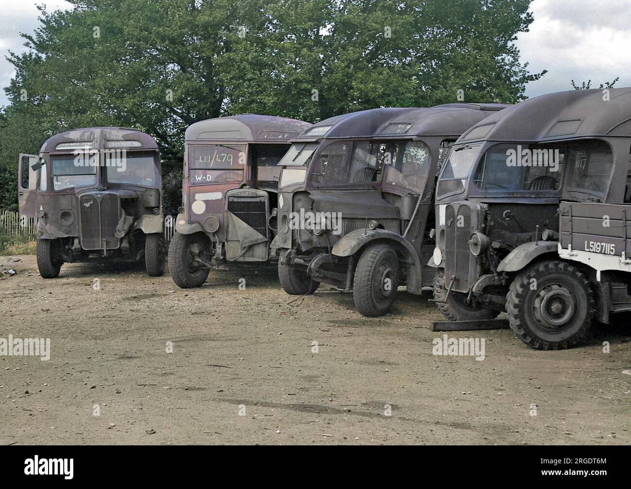 Vehicles in a yard, waiting to be repaired, or perhaps they are beyond repair and are being held for spare parts. Stock Photo