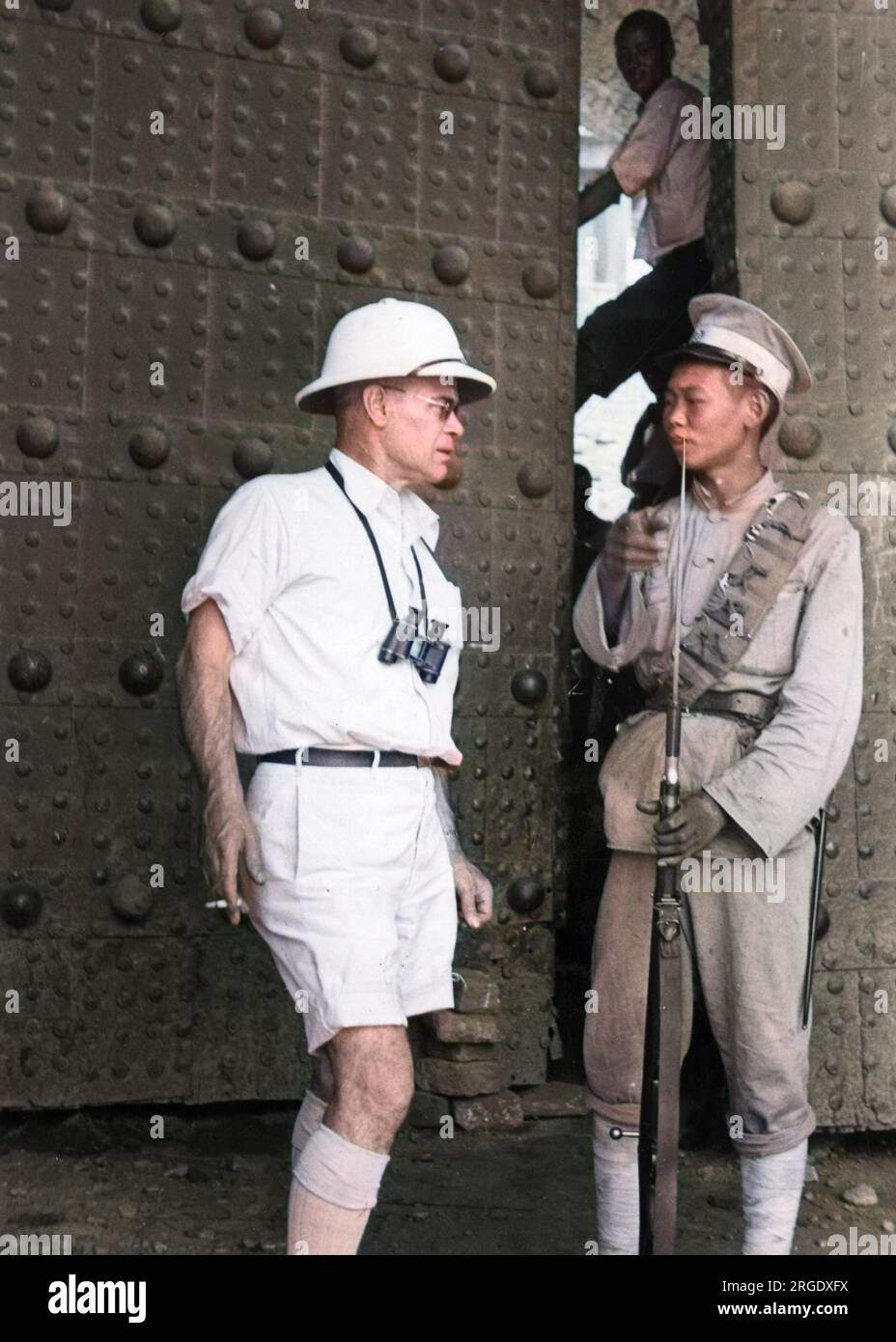 A foreign correspondent speaks to the policeman guarding the Peking City gates. Peking (Beijing) had fallen to the Japanese in 1937 Stock Photo