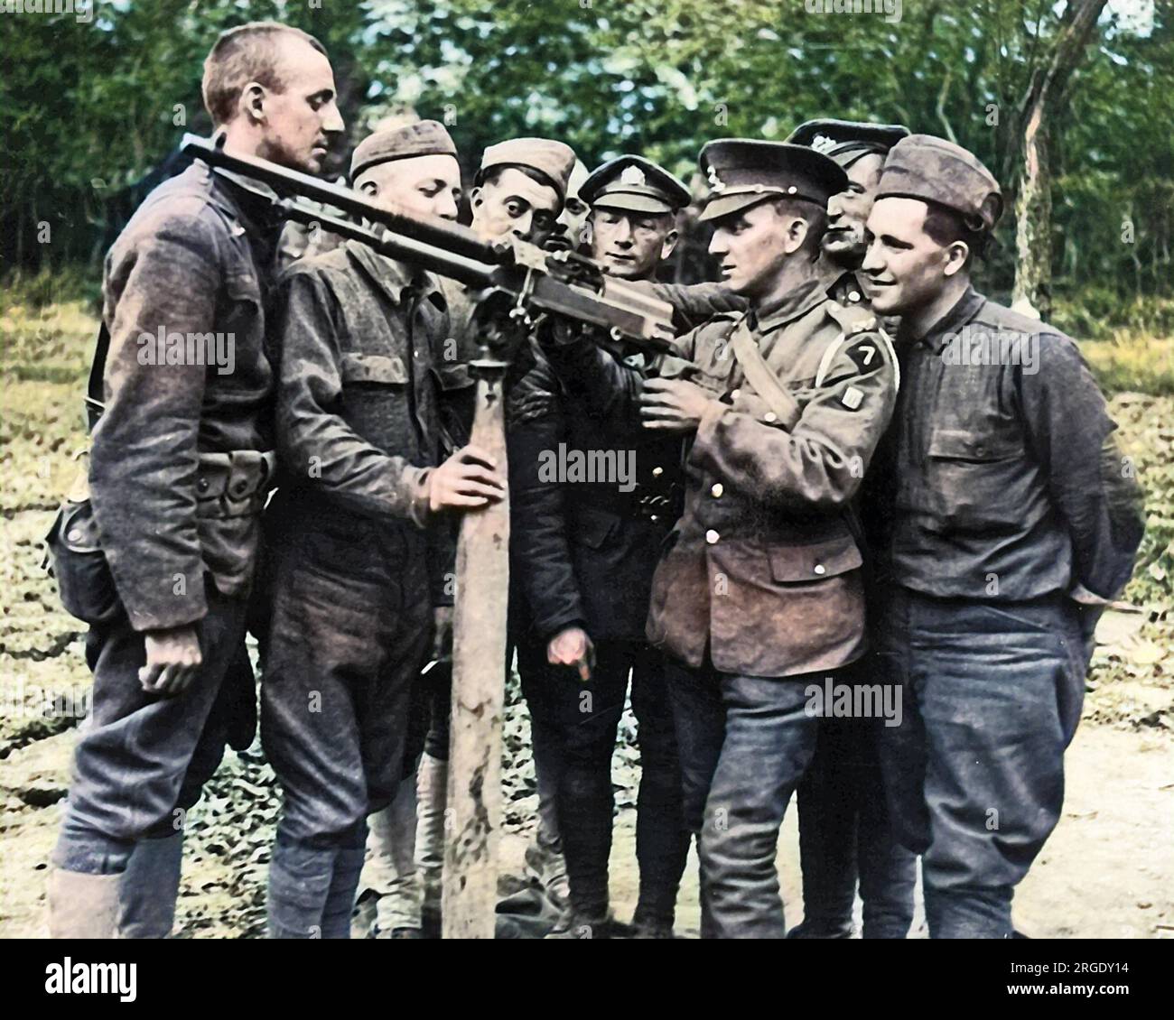 A British machine gunner demonstrates the workings of a gun to American troops on the Western Front in France during World War One. Stock Photo