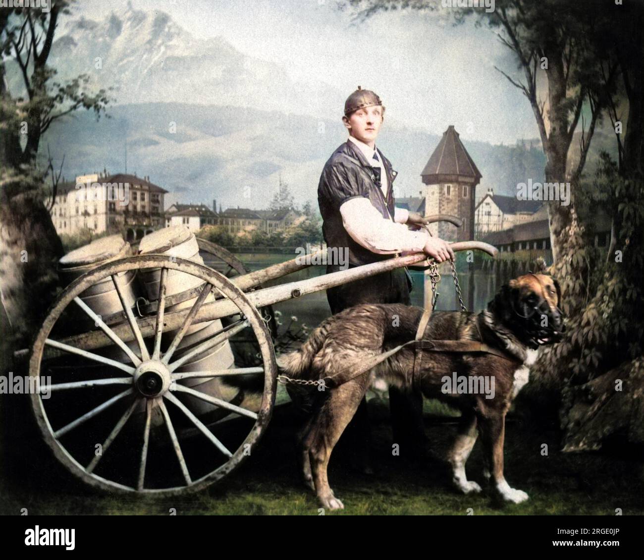 Man (possibly Belgian) and dog with a milk cart, in a studio photo with a painted backdrop. Stock Photo