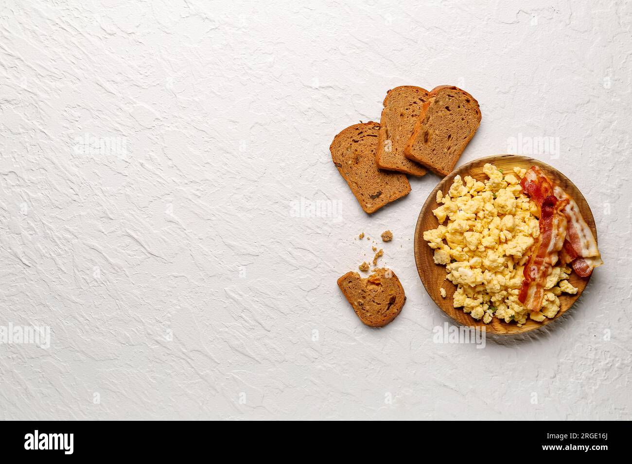 Plate of tasty scrambled eggs with bacon on white background Stock ...