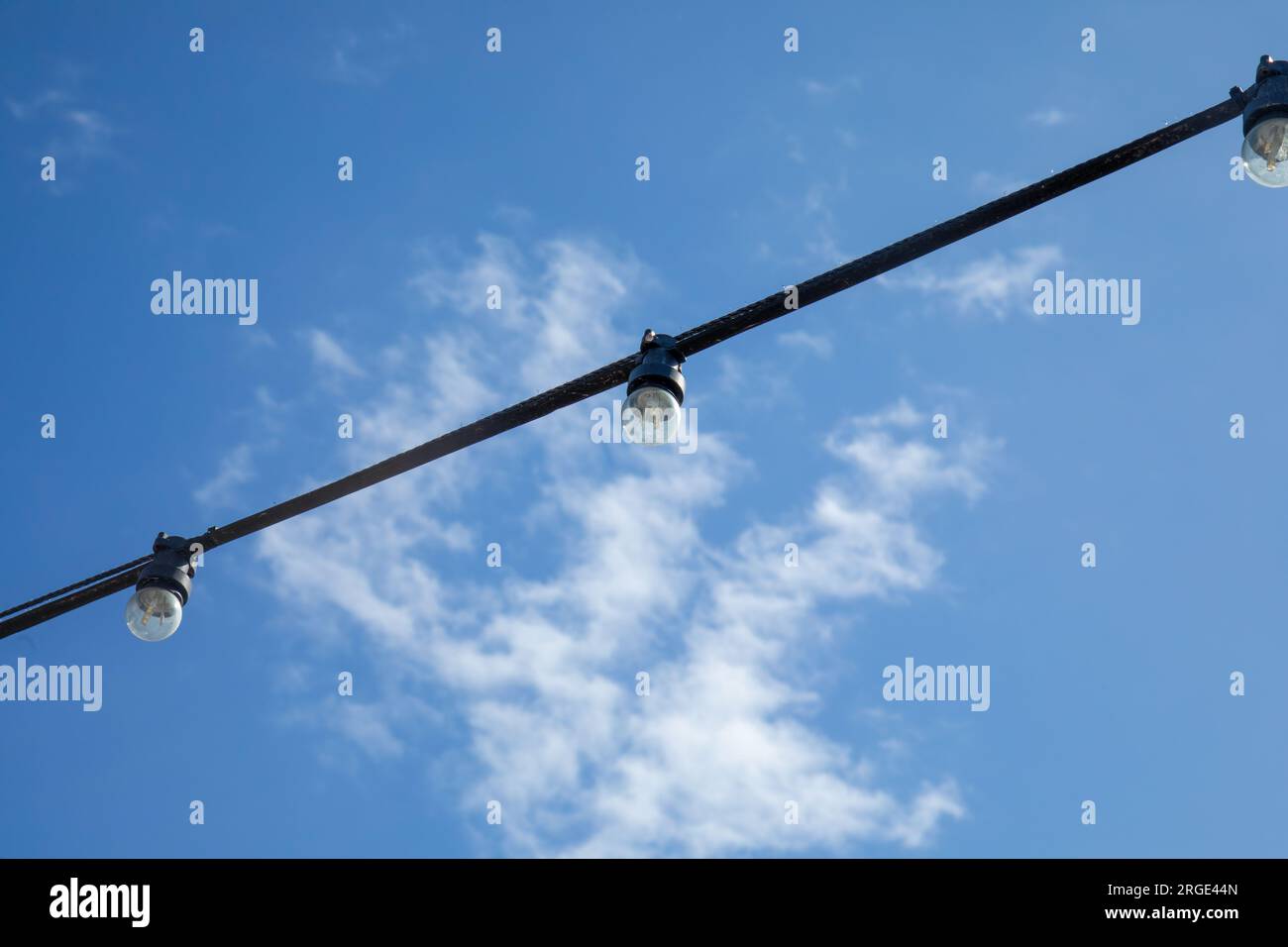 String of festival street lights against a bright blue sky Stock Photo Alamy