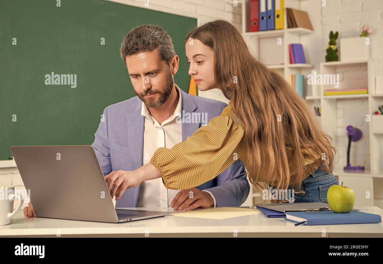 cheerful teen girl with man teacher in classroom. education Stock Photo ...