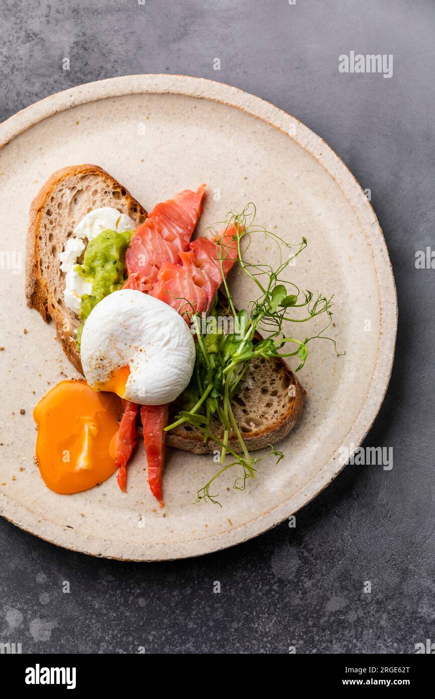 Sandwich with red fish, guacamole and poached egg Stock Photo