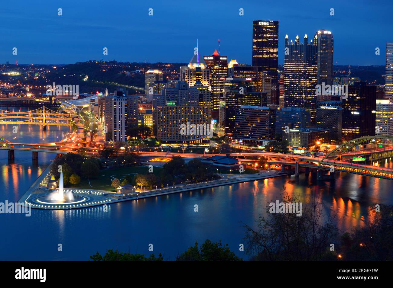 The lights of the Pittsburgh skyline are reflected in the surrounding waters of the Ohio, Allegheny and Monongahela Rivers at night Stock Photo