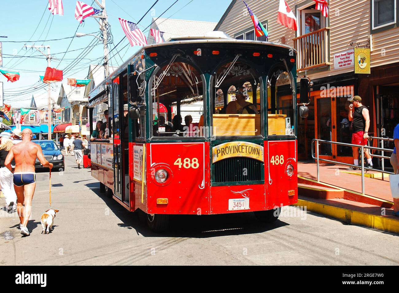 A tour guide drives a trolley car through the busy streets of