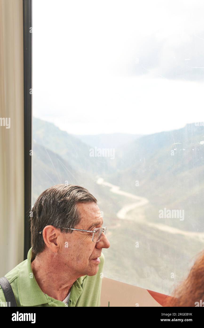 Senior hispanic man enjoying a cable car ride over the Chicamocha Canyon, in Santander, Colombia Stock Photo