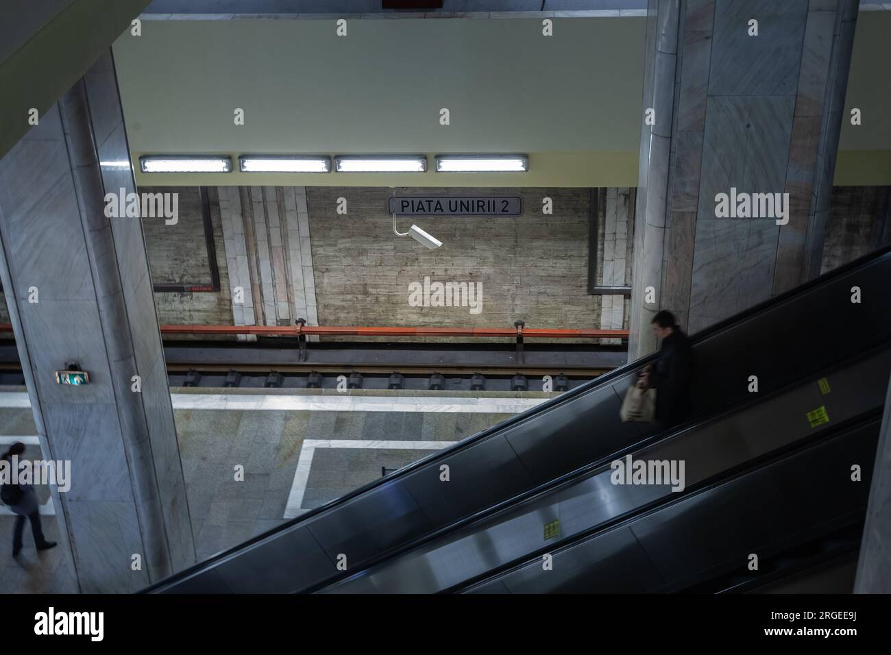 Picture of a man going down the escalators of Piata Unirii metro