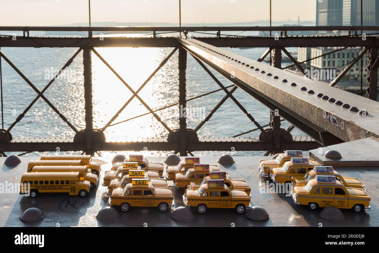 a set of souvenirs in the shape of yellow taxis on the metal structure of the Brooklyn Bridge Stock Photo