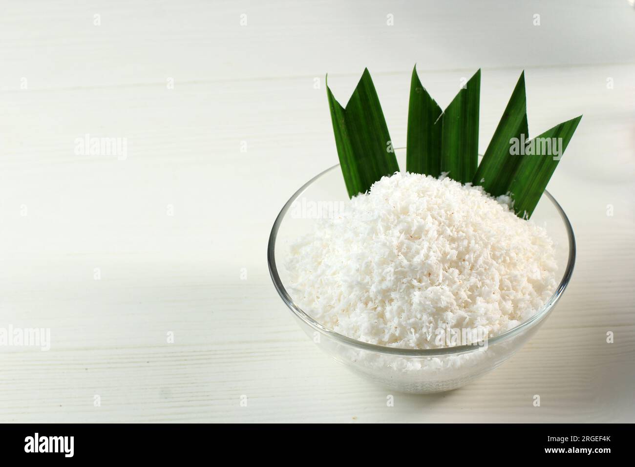 Grated Coconut with Pandan Leaf on White Table Stock Photo