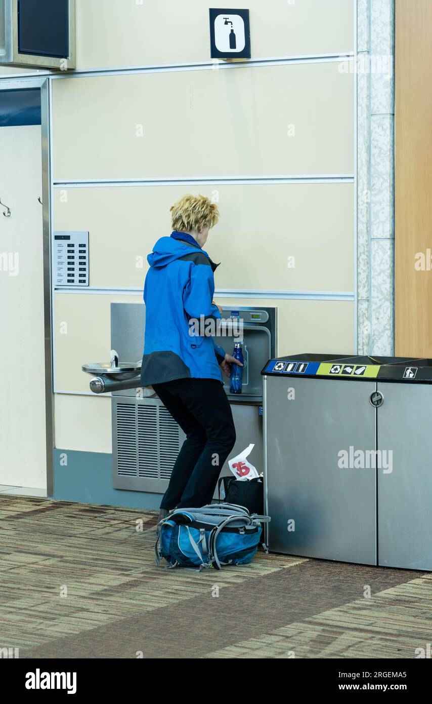Edmonton, Canada, April 7, 2023: A traveler is filling an empty water container after security check. Curtesy of Edmonton International Airport Stock Photo