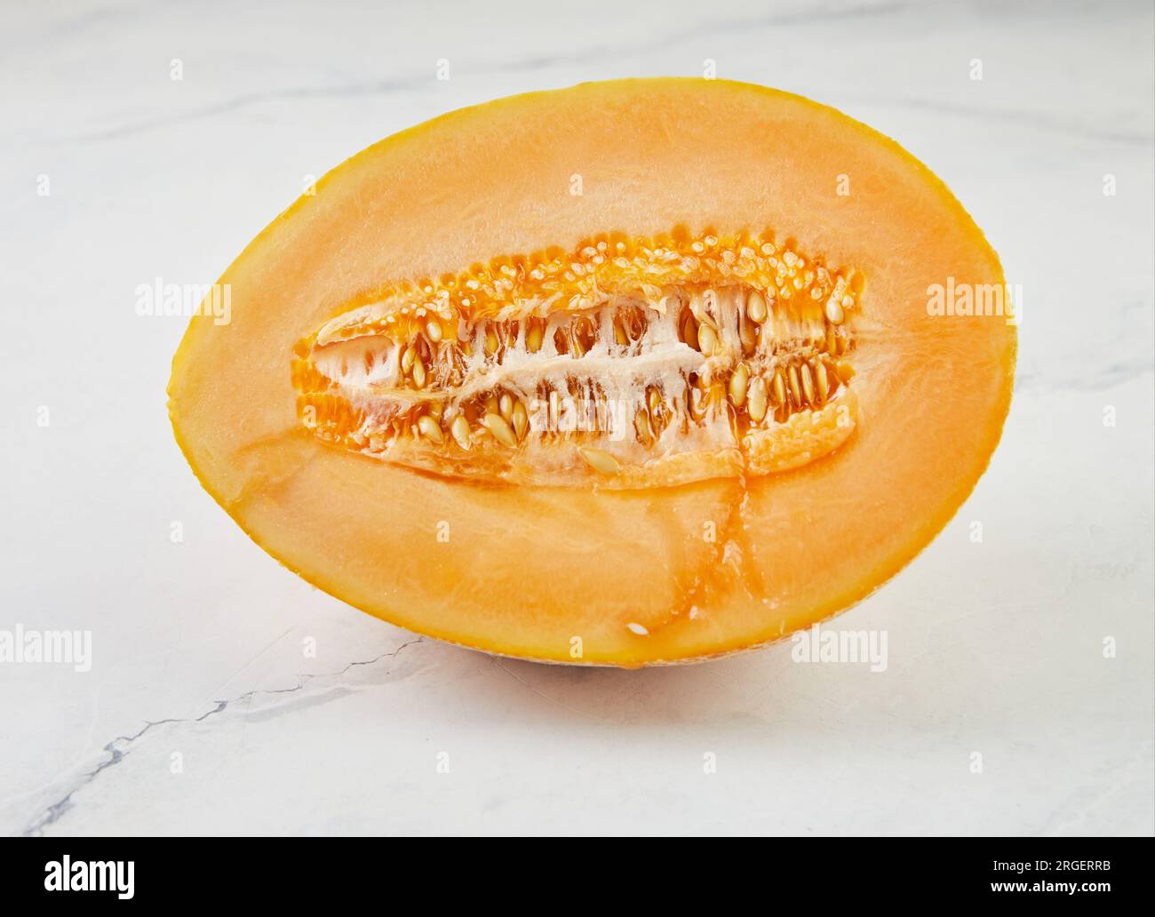 Melon half on light marble in the home kitchen Stock Photo