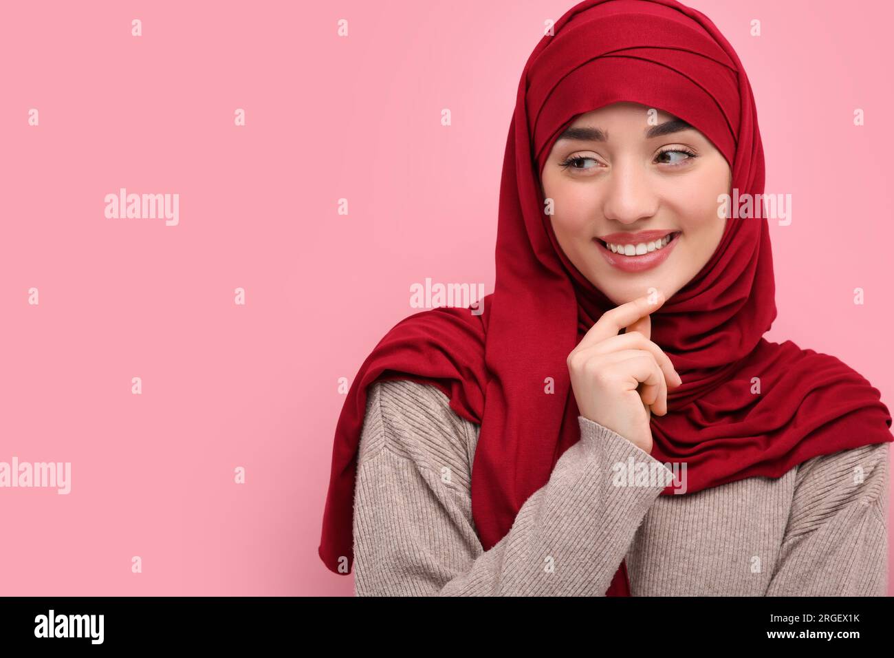 Portrait of Muslim woman in hijab on pink background, space for text ...