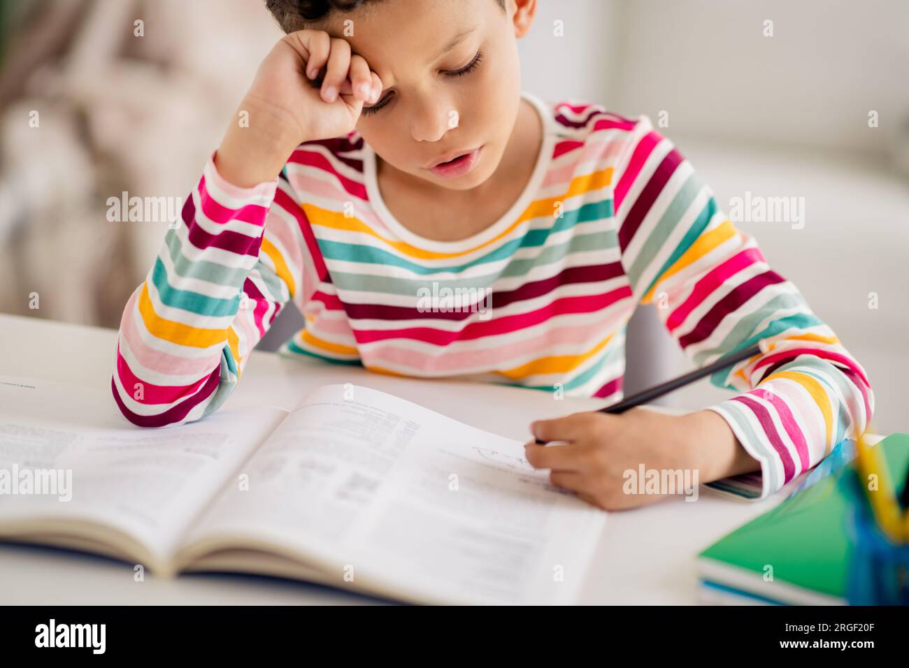 Closeup photo of childhood diligent young small boy writing copybook