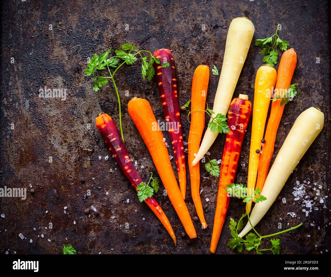 raw rainbow carrot for roasting, on a baking tray Stock Photo Alamy