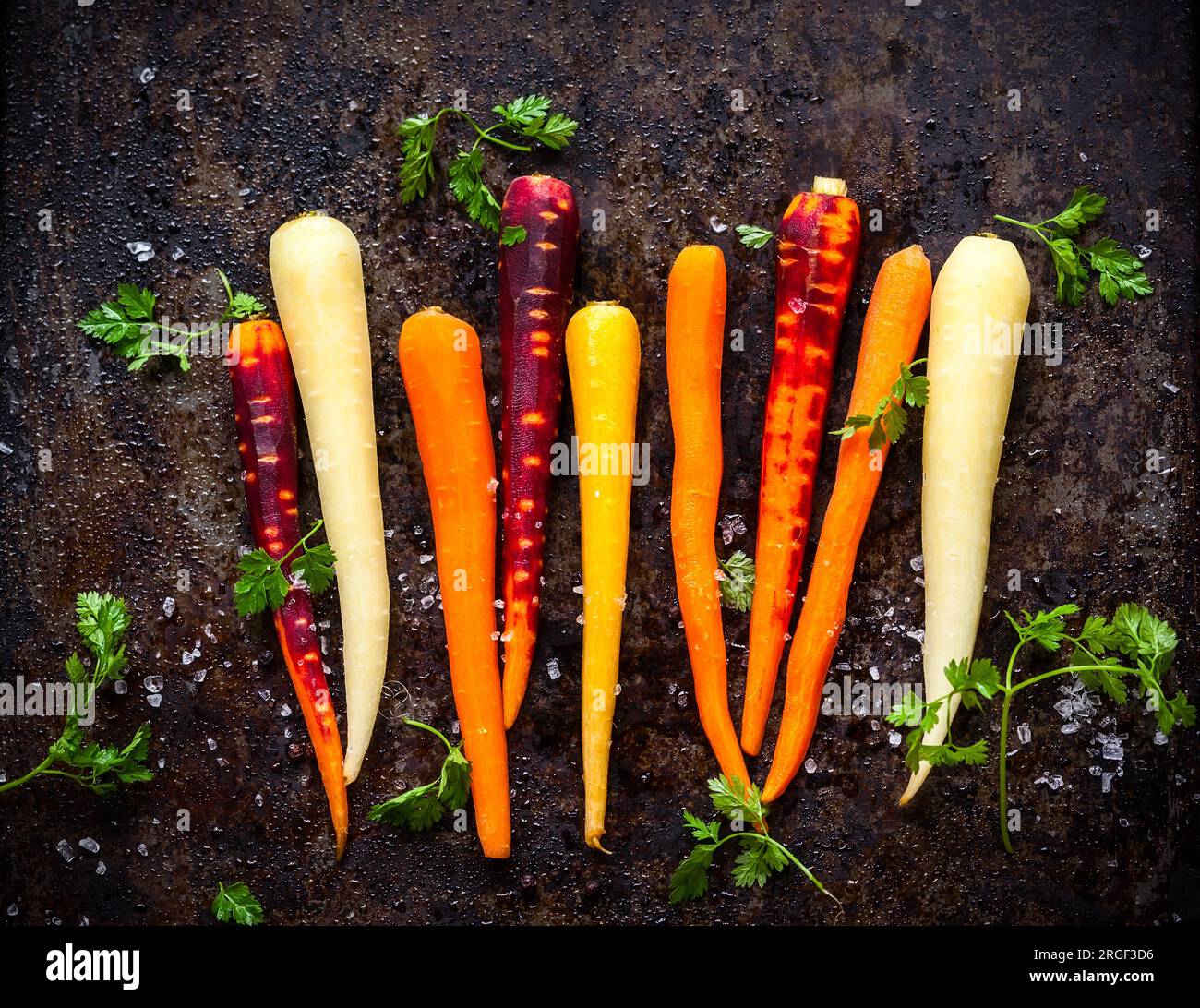 raw rainbow carrot for roasting, on a baking tray Stock Photo Alamy
