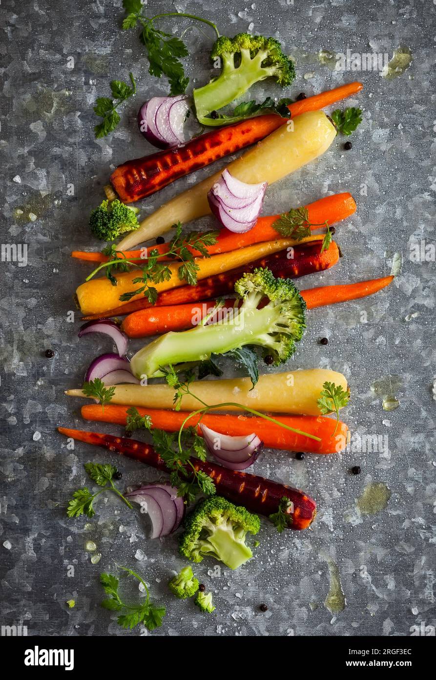 raw rainbow carrot , broccoli and onion for roasting, on the vintage