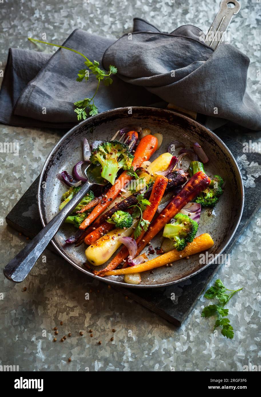 roasted rainbow carrot and broccoli in a vintage pan, rustic style
