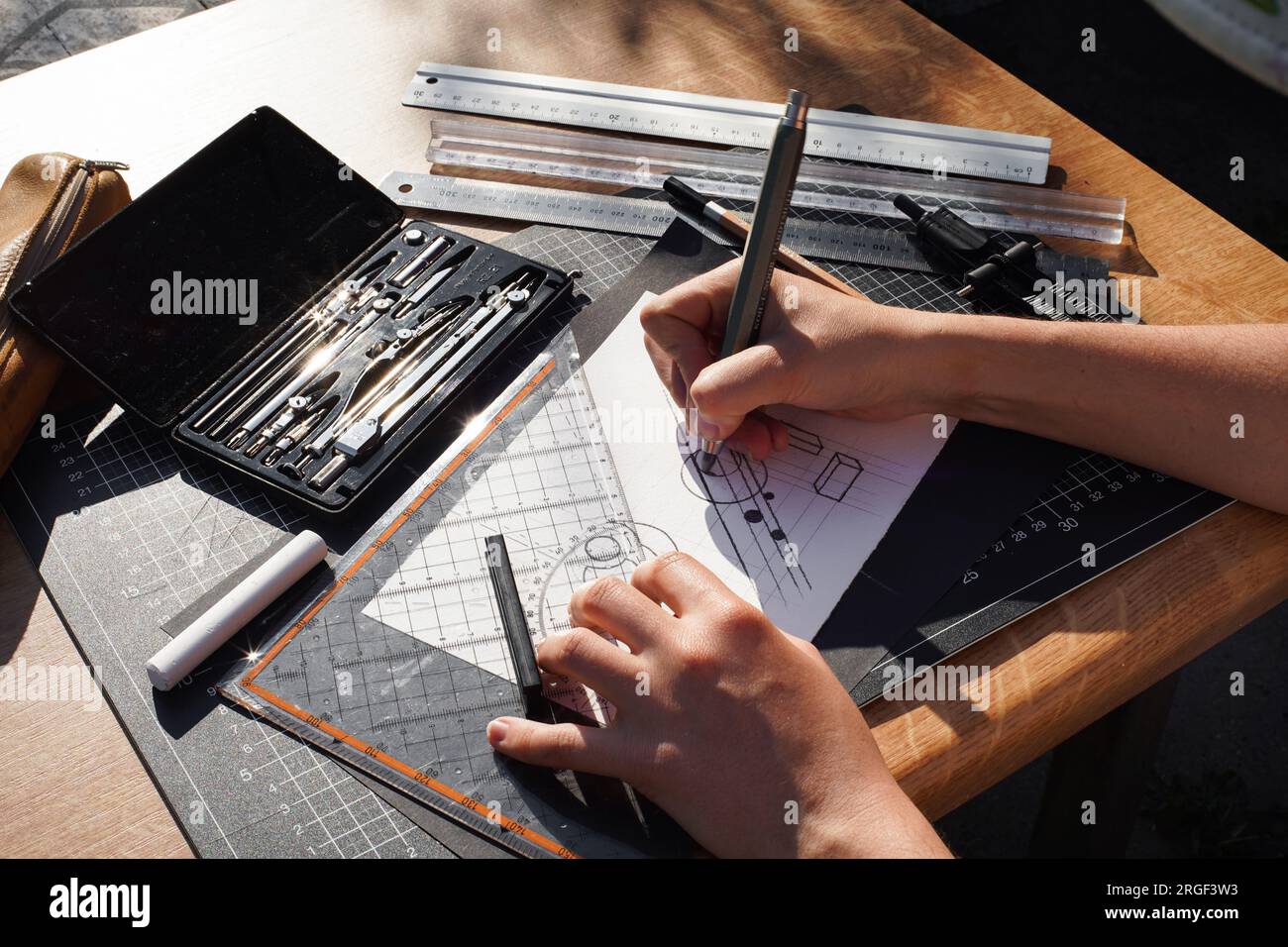 Architect and designer working accurately on a project drawing sketches and technical drafts on paper using professional tools like rulers compass and Stock Photo