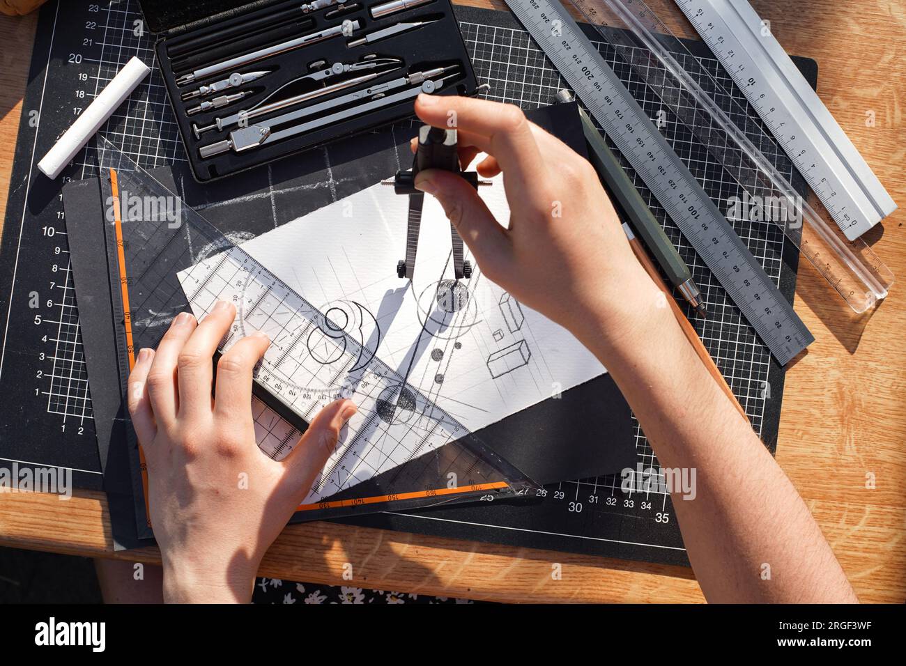 Architect and designer working accurately on a project drawing sketches and technical drafts on paper using professional tools like rulers compass and Stock Photo