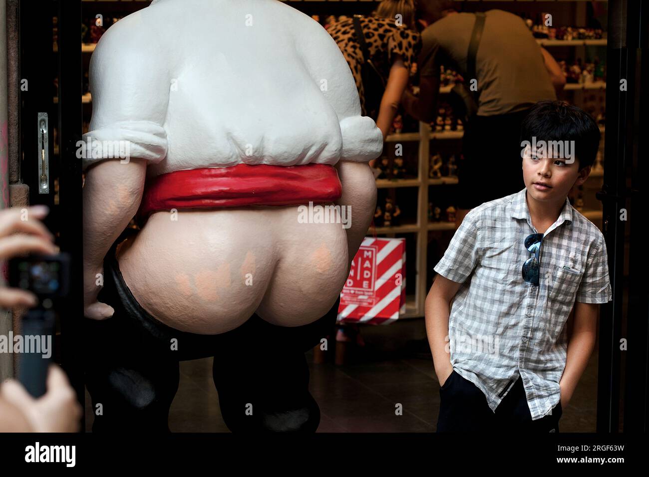 A boy posing for a photo next to a ' caganer ', Barcelona. Stock Photo