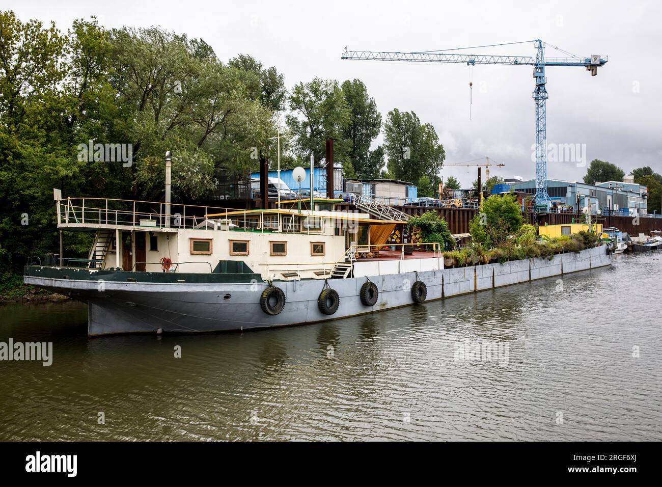 houseboat with many plants in the Rhine harbor in the district Muelheim, Cologne, Germany. Hausboot mit vielen Pflanzen im Rheinhafen im Stadtteil Mue Stock Photo