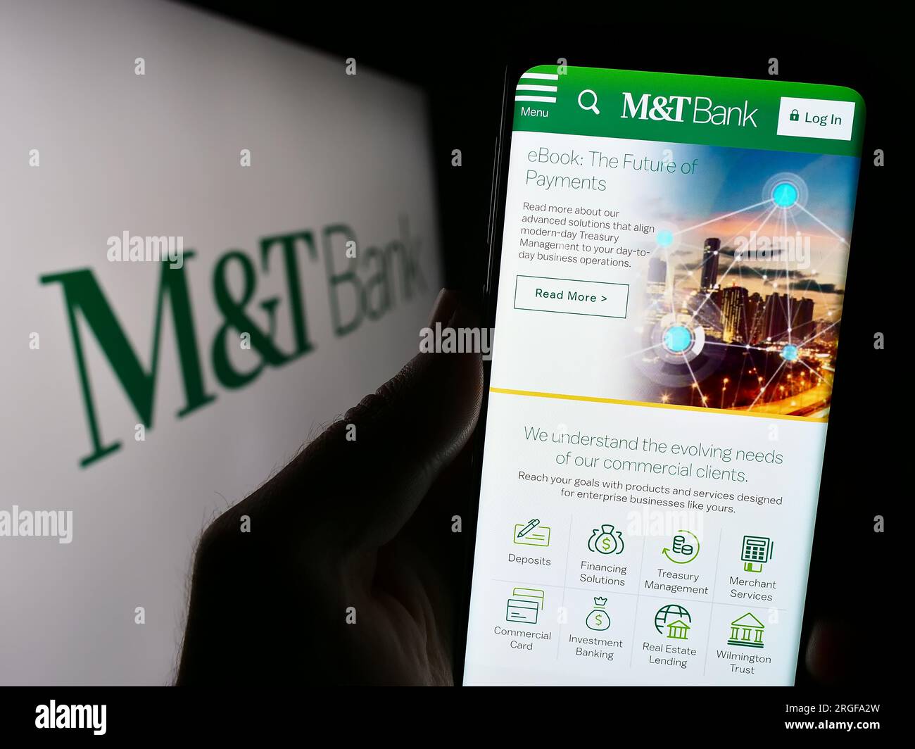 Person holding cellphone with website of US financial company MT Bank Corporation on screen in front of logo. Focus on center of phone display. Stock Photo