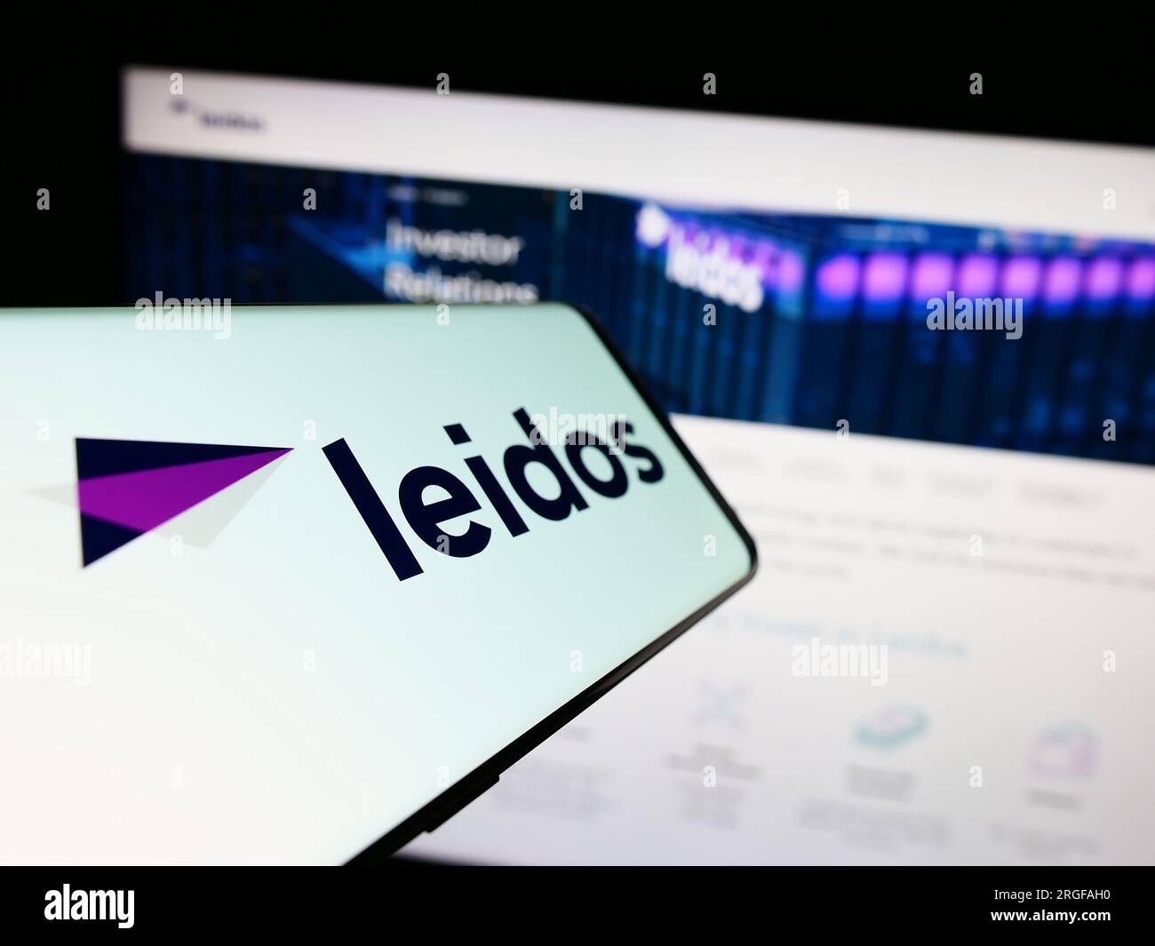 Smartphone with logo of American defense company Leidos Inc. on screen in front of business website. Focus on center-left of phone display. Stock Photo