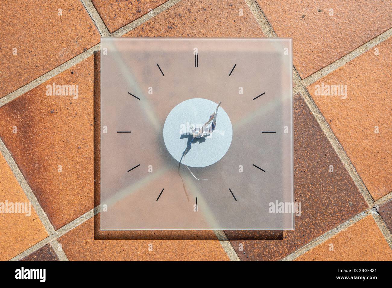 A clock face with bent and broken clock hands on a tiled floor Stock Photo Alamy
