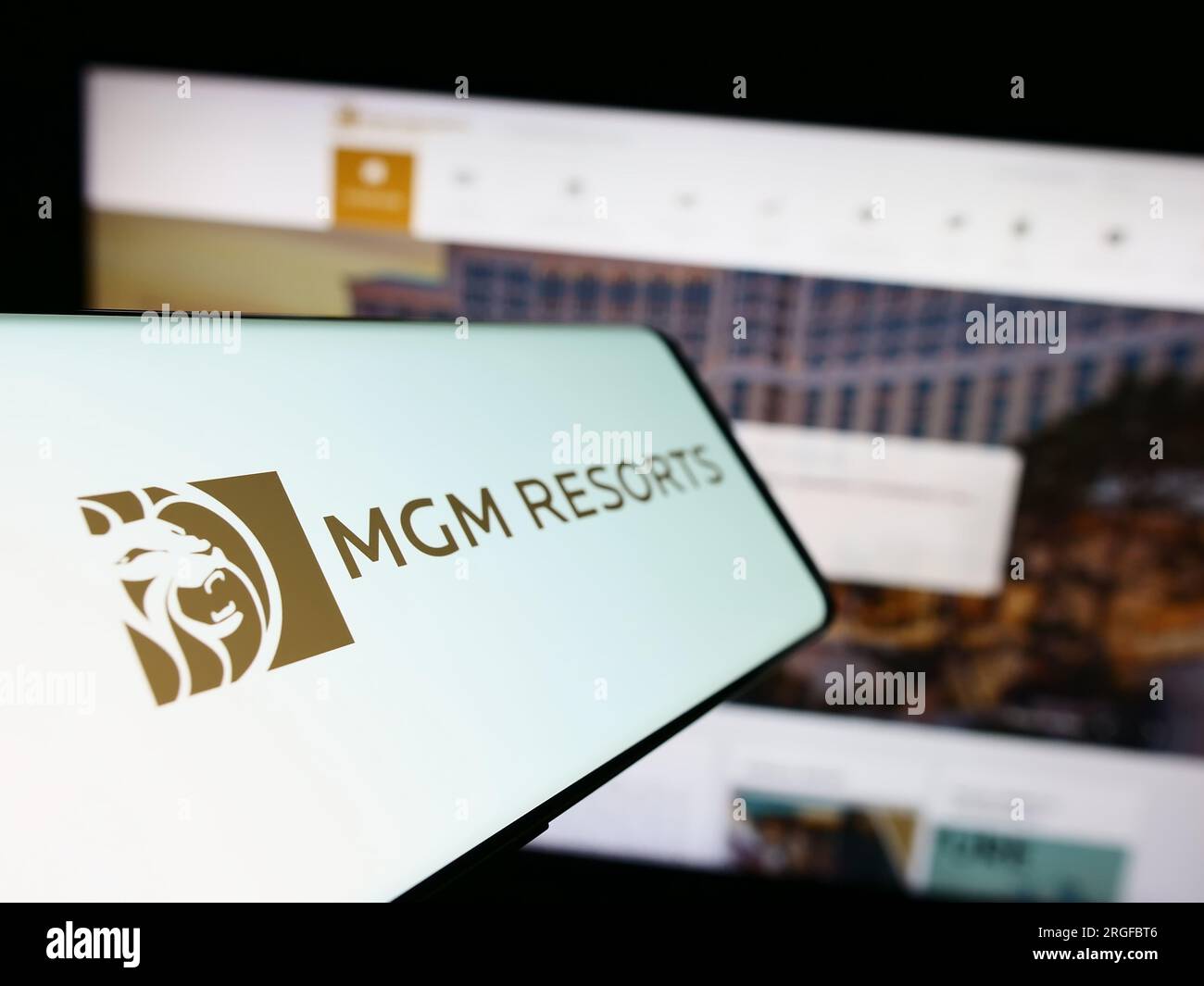 Smartphone with logo of hospitality company MGM Resorts International on screen in front of business website. Focus on left of phone display. Stock Photo