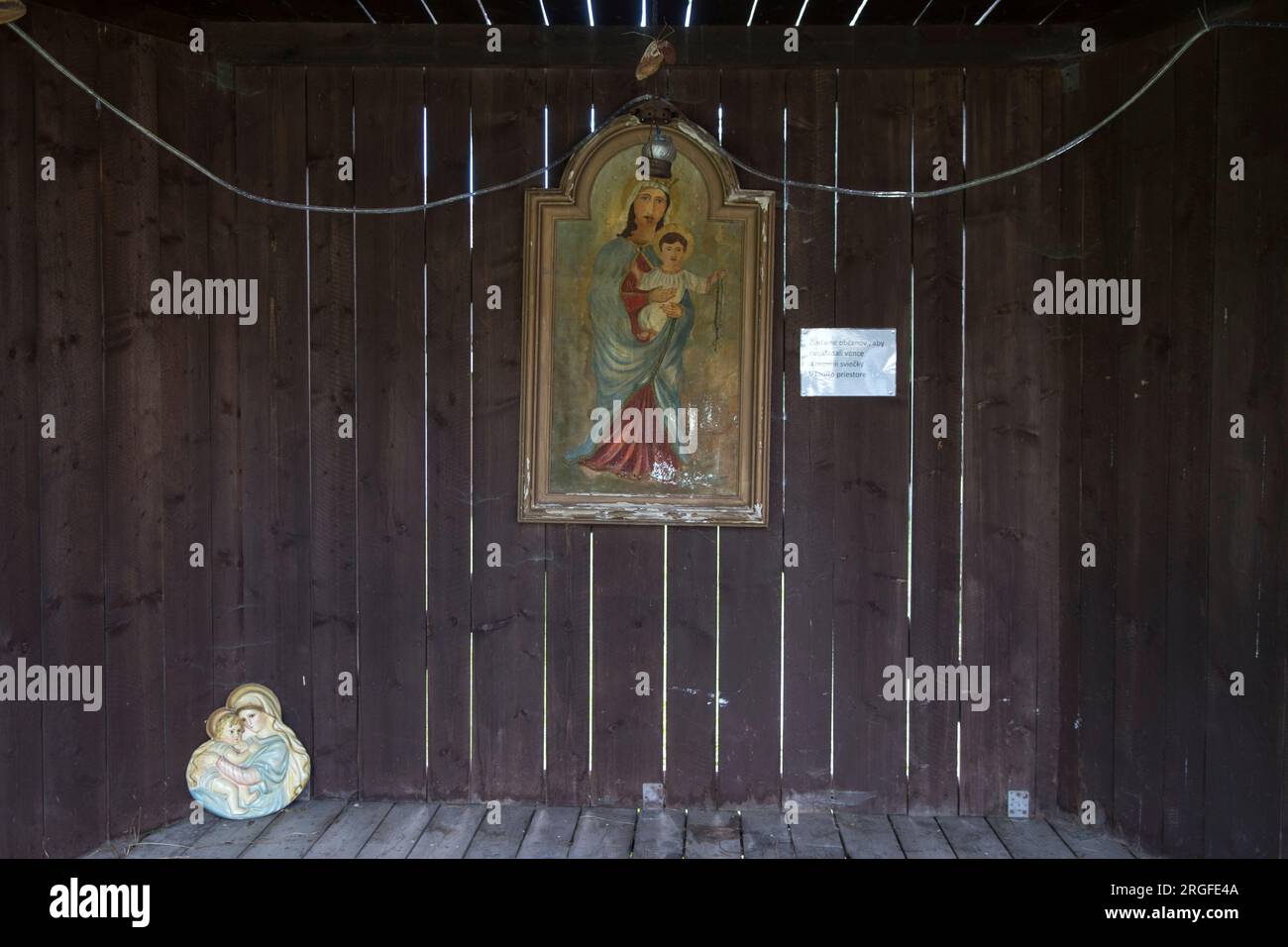 Primitive oil painting of the Madonna and Child, situated in wooden shelter by the church of St Matthew, where a Christmas nativity scene is displayed. Sumiac, Brezno District, Slovakia August 2023. 2020s HOMER SYKES Stock Photo