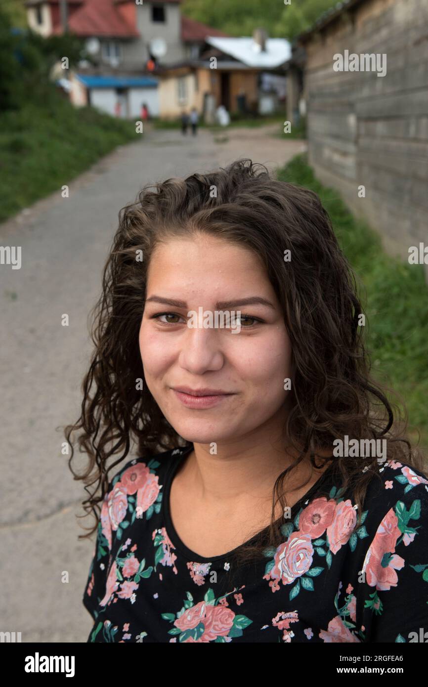 Romany gypsy girl teenager,multi generational house in background. Gypsy settlement on the outskirts of Sumiac, Brezno District, Slovakia August 2023. 2020s HOMER SYKES Stock Photo