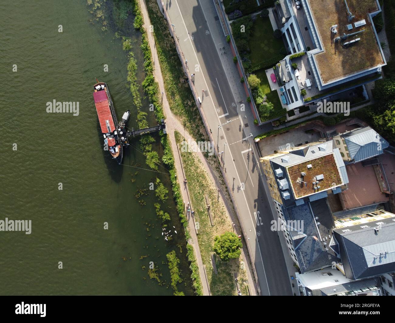 Aerial top down view of the river bank and a moored boat in Neuenheim, Heidelberg, Germany Stock Photo