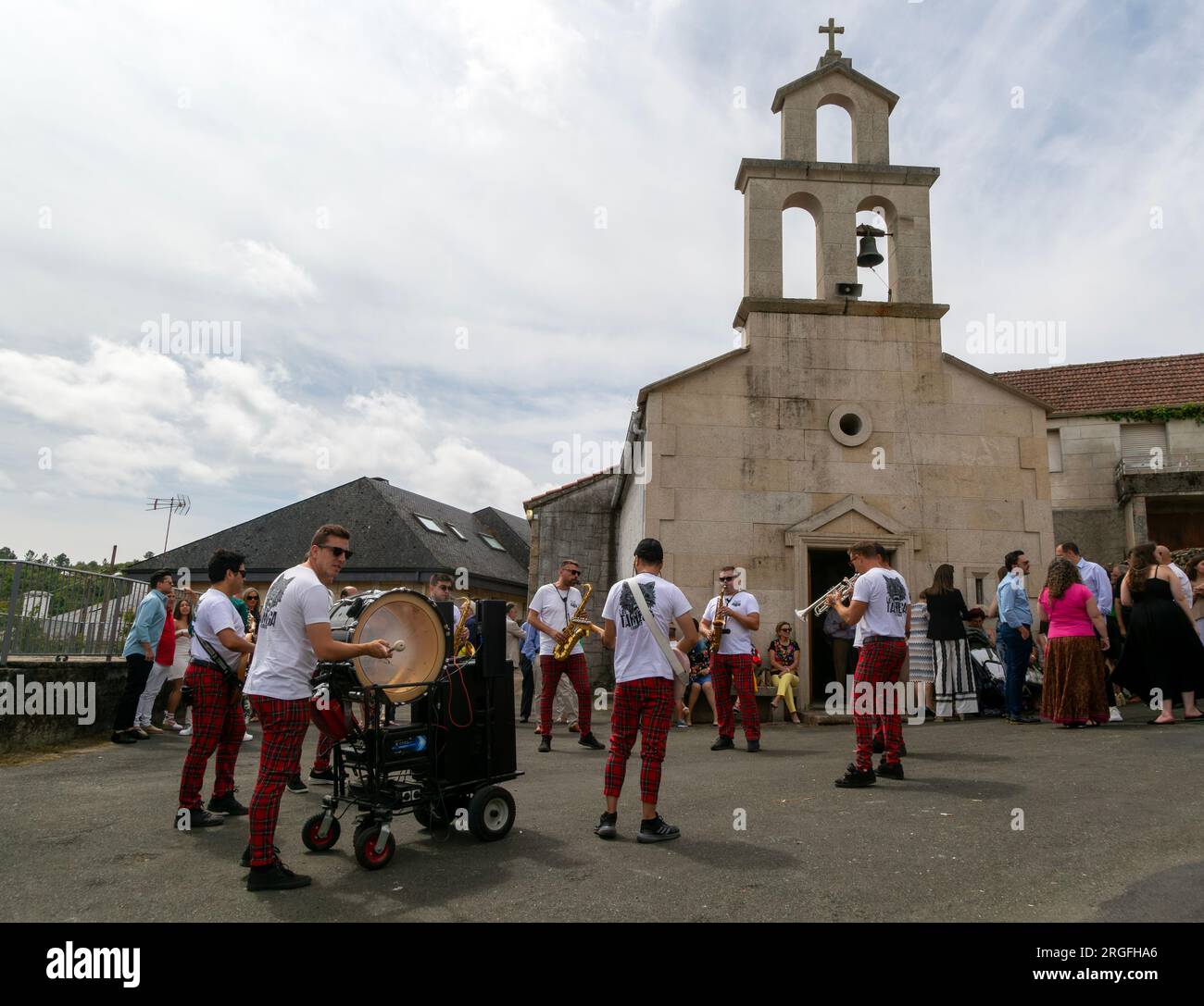 Village fiesta musicians and villagers outside chapel church, Rubillon, Ourense province, Galicia, Spain Stock Photo