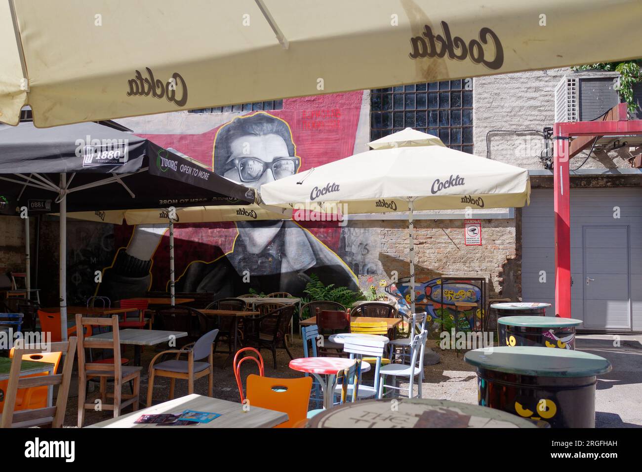 Outdoor cafe/restaurant area with an illustration of Buddy Holly on the wall, in the city of Belgrade, Serbia. August 9, 2023. Stock Photo