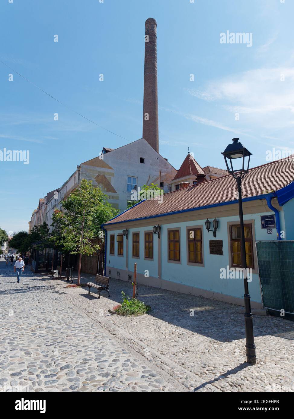 The famous bohemian cobbled Skadarlija street with cafes and restaurants and chimney of the old brewery. Belgrade, Serbia. August 9, 2023.. Stock Photo