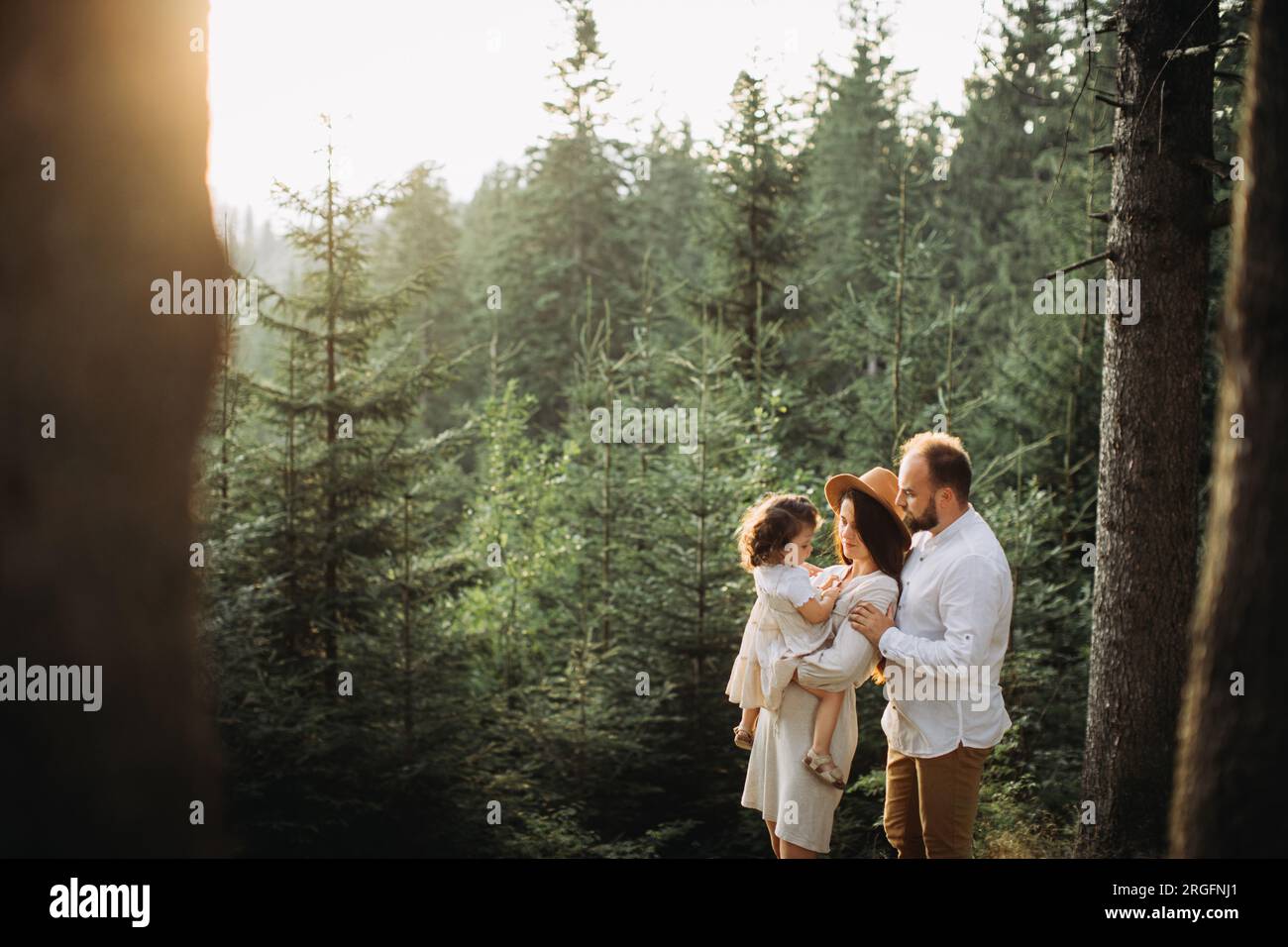 Happy family relaxing in pine forest Stock Photo