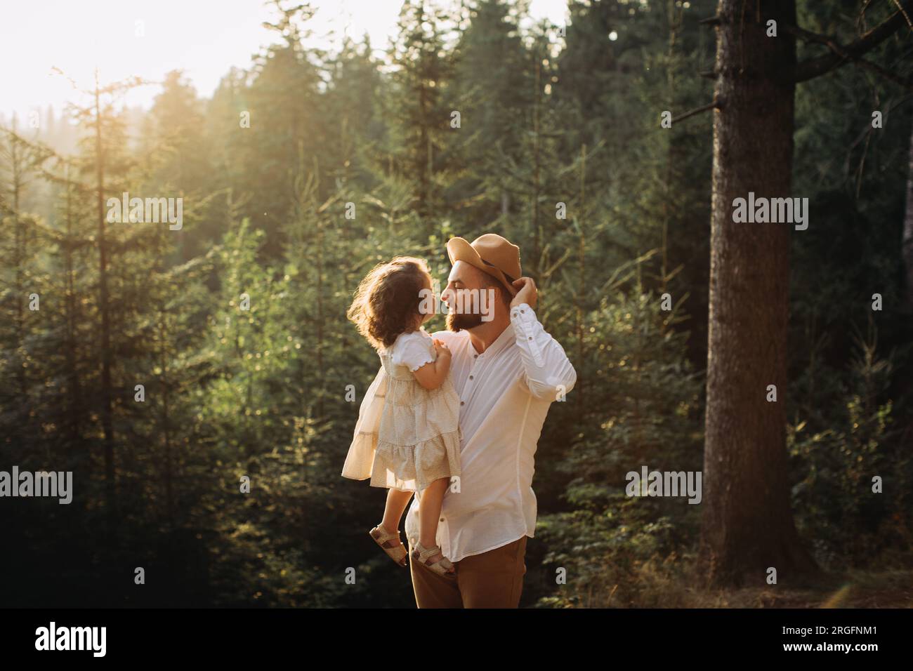 Happy father and daughter relaxing in sunny pine forest Stock Photo - Alamy