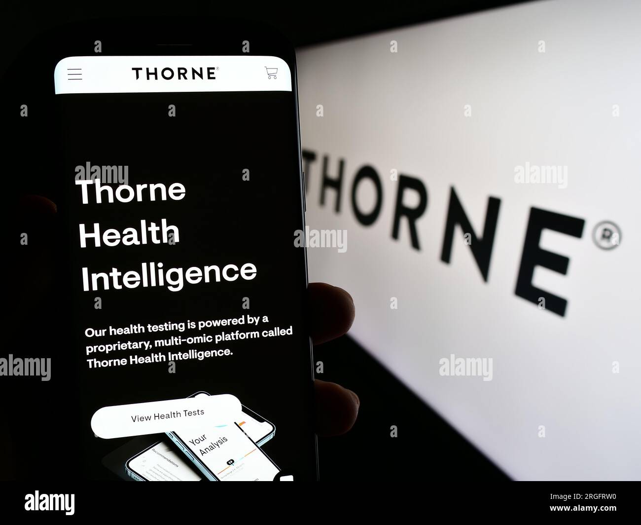 Person holding smartphone with web page of US wellness company Thorne HealthTech Inc. on screen with logo. Focus on center of phone display. Stock Photo