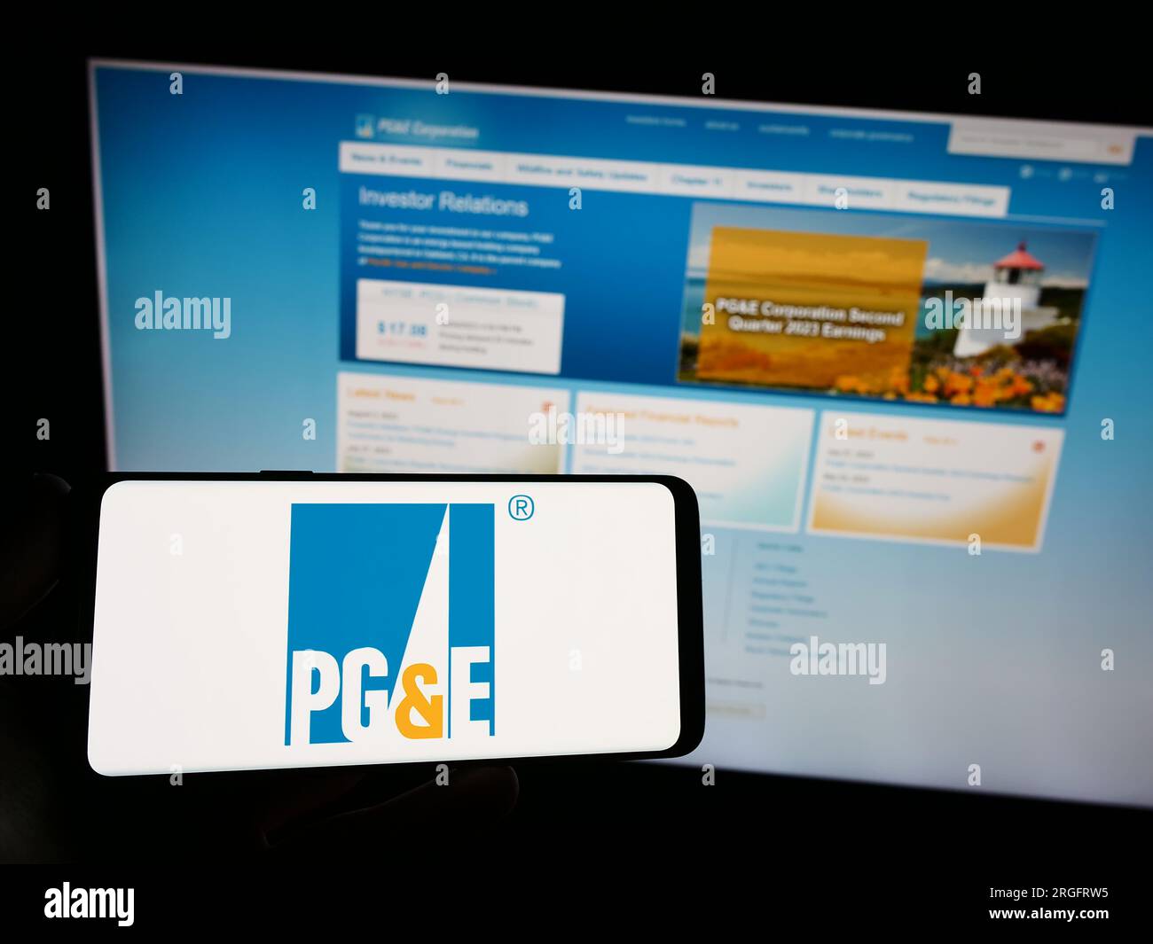 Person holding mobile phone with logo of utility Pacific Gas and