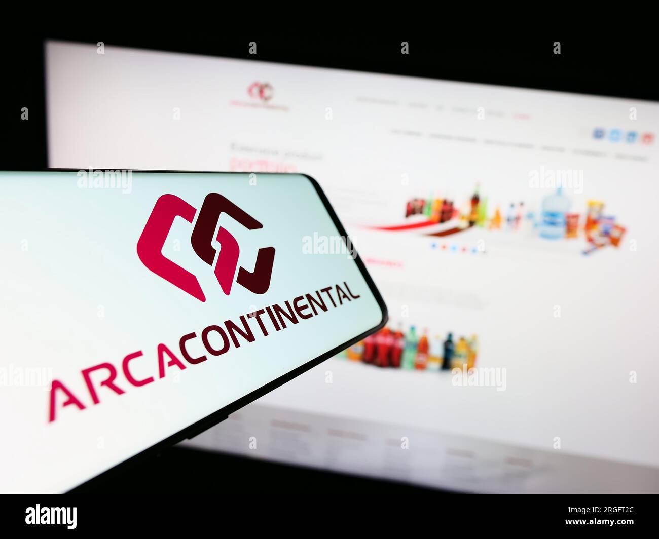 Smartphone with logo of Mexican company Arca Continental SAB de CV on screen in front of website. Focus on center-right of phone display. Stock Photo