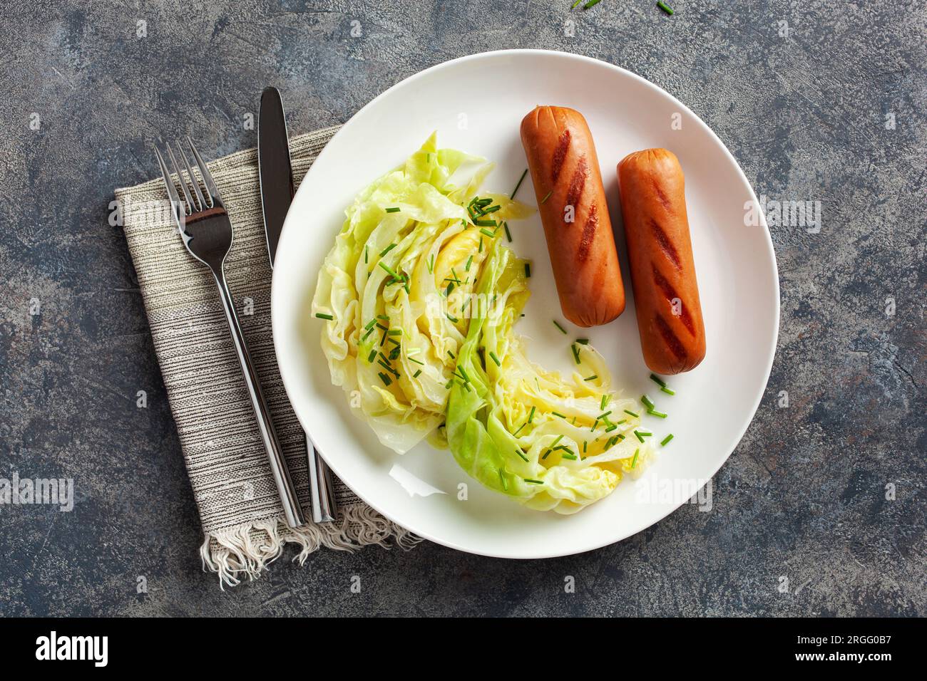 grilled sausages and stewed steamed cabbage with butter, healthy keto meal Stock Photo