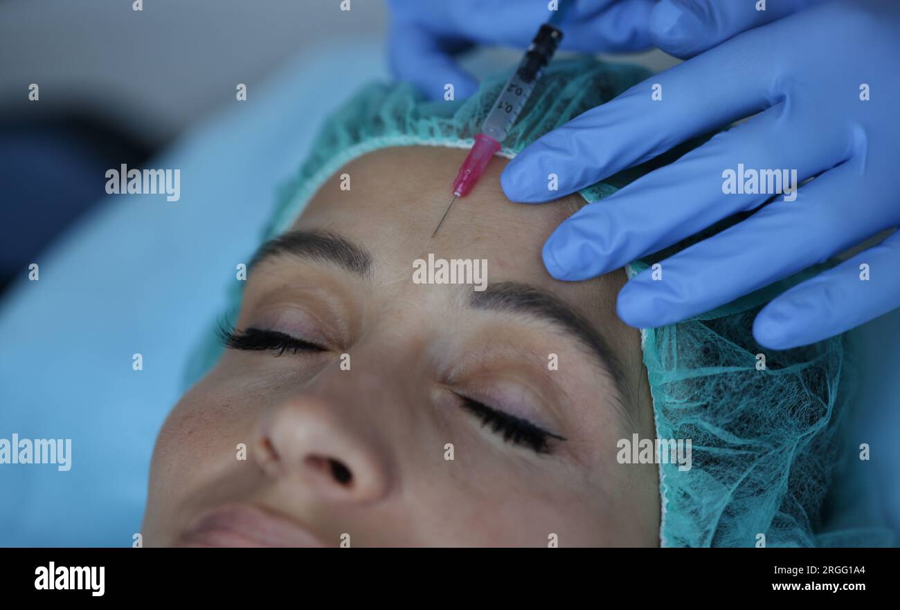 Portrait of woman who gets an injection between her eyebrows. Stock Photo