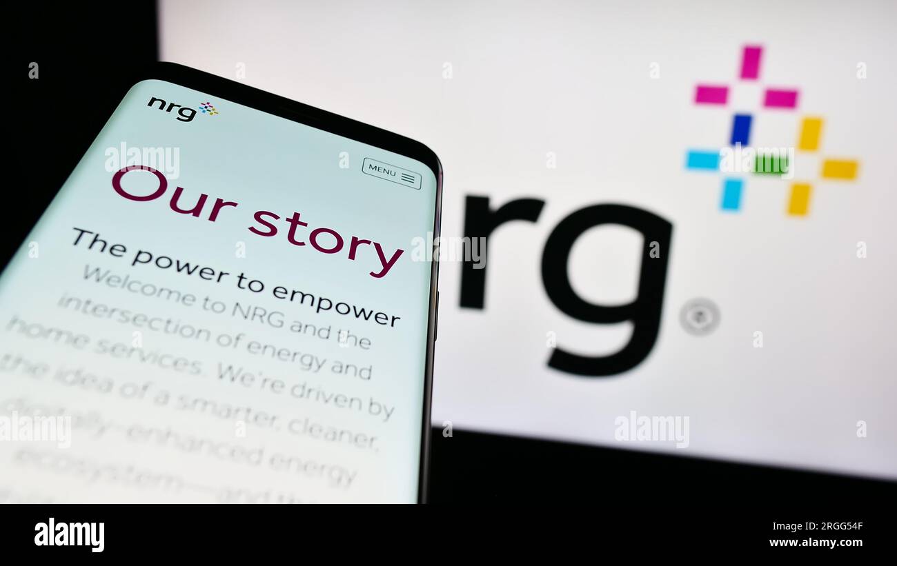 Mobile phone with website of US utility company NRG Energy Inc. on screen in front of business logo. Focus on top-left of phone display. Stock Photo