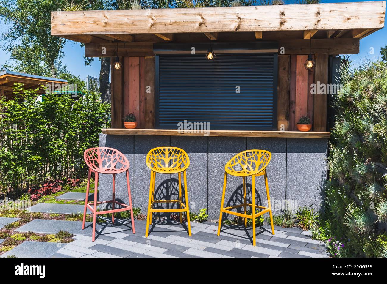 Bar with metal bar stools in a contemporary garden setting, nobody Stock Photo - Alamy