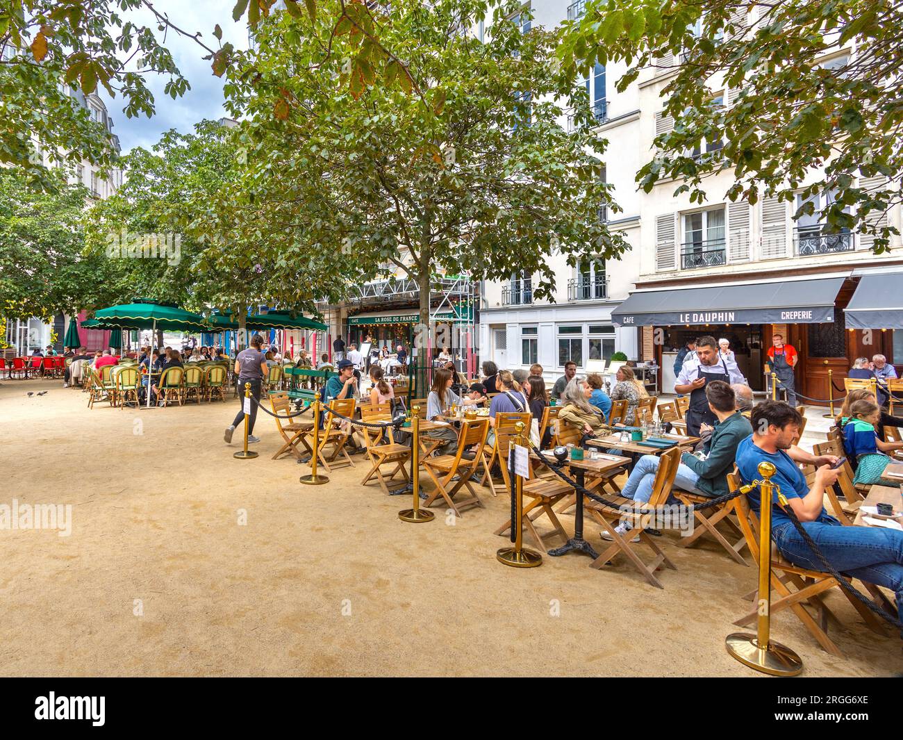 Crowded lunchtime diners at open-air cafes and restaurants in the Place Dauphine, Paris. Stock Photo