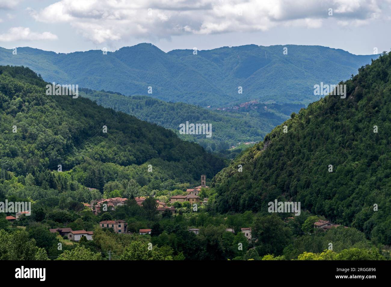 Surrounded by steep wooded mountain slopes and on the valley floor of Valle Ombrosa (Shady Valley) with olive groves and farming is the hamlet of Posa Stock Photo