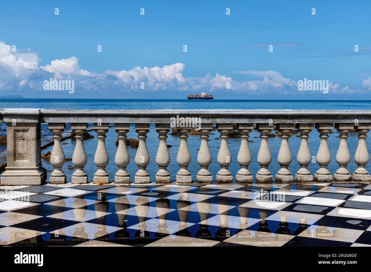 View of elegant balustrade on Terrazza Mascagni scenic seaside promenade in Livorno, Italy with reflection in wet black-and-white checkerboard pavemen Stock Photo